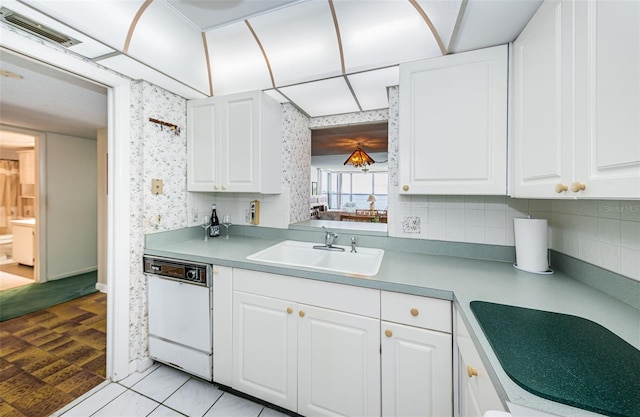 300 Woodette Dr Unit 202B, Dunedin, FL 34698 - kitchen with dishwasher, wallpapered walls, white cabinets, light countertops, and backsplash