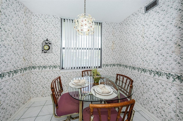 300 Woodette Dr Unit 202B, Dunedin, FL 34698 - dining room featuring wallpapered walls, a chandelier, light tile patterned floors, and a textured ceiling