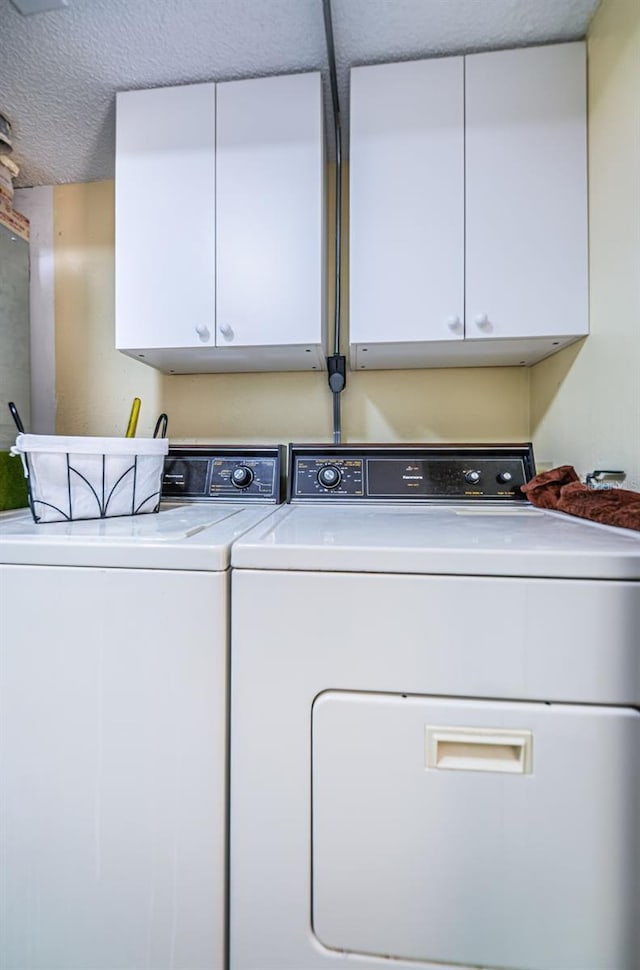 300 Woodette Dr Unit 202B, Dunedin, FL 34698 - washroom with washing machine and dryer, cabinet space, and a textured ceiling