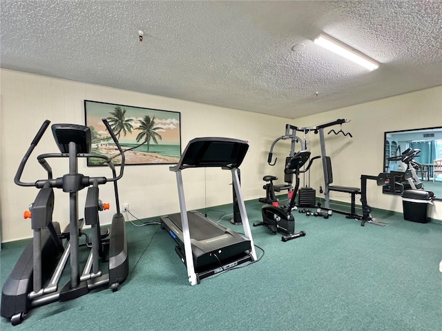 exercise room featuring a textured ceiling and carpet flooring