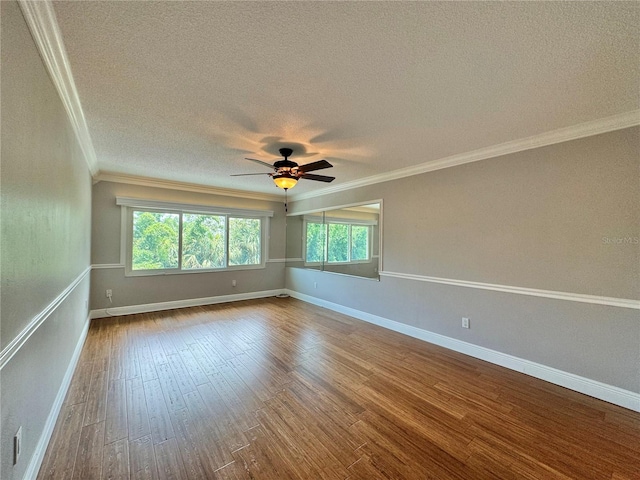 spare room featuring a wealth of natural light, crown molding, hardwood / wood-style floors, and ceiling fan