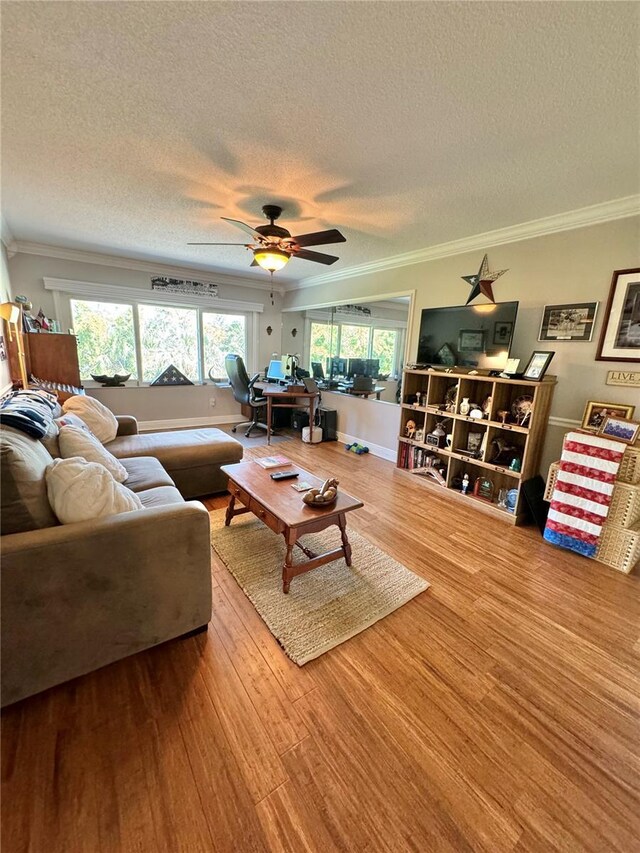 living room featuring crown molding, wood-type flooring, and a healthy amount of sunlight