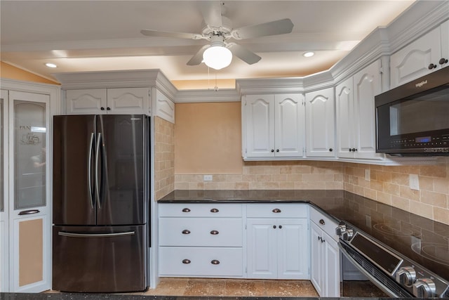 kitchen with freestanding refrigerator, electric stove, white cabinetry, and dark countertops