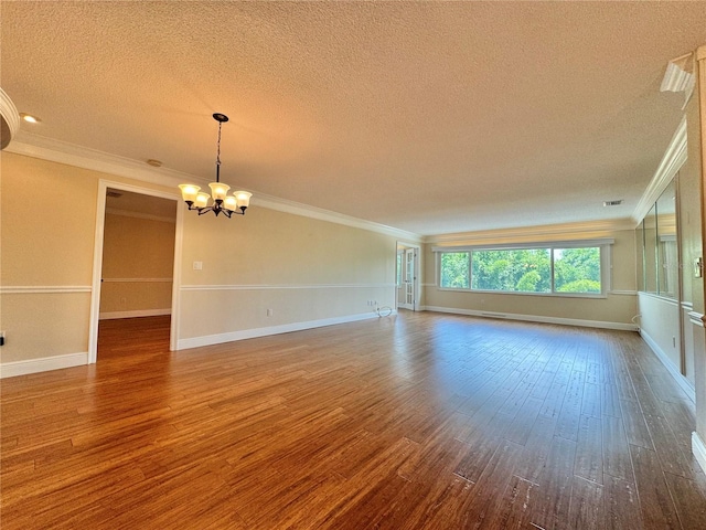 unfurnished living room with hardwood / wood-style flooring, crown molding, a textured ceiling, and a chandelier