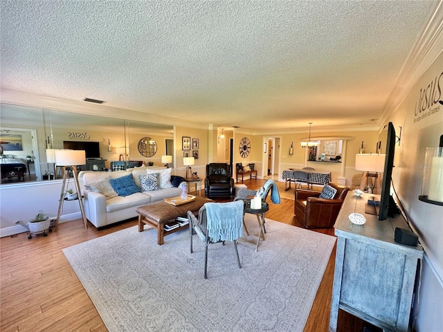 living room featuring ornamental molding, a textured ceiling, and wood-type flooring