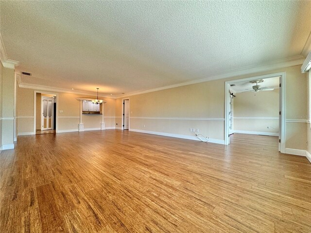 unfurnished living room with a textured ceiling, crown molding, and light wood-type flooring