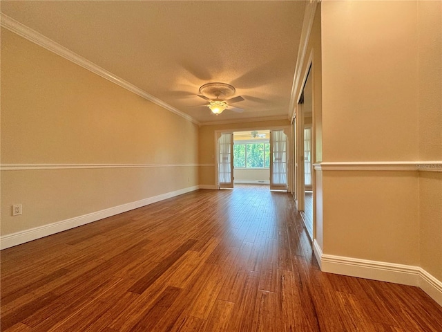 empty room featuring ceiling fan, crown molding, wood-type flooring, and a textured ceiling