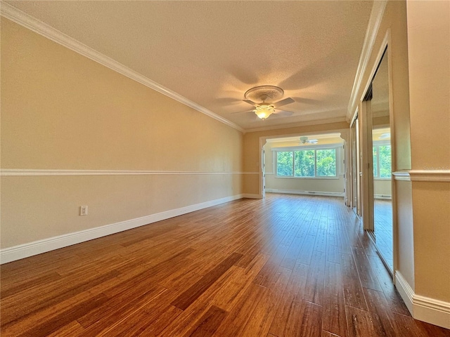 empty room with ceiling fan, hardwood / wood-style flooring, crown molding, and a textured ceiling