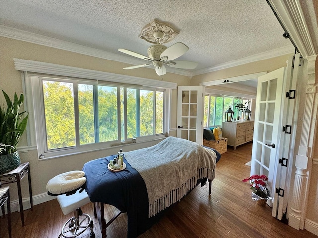 bedroom featuring hardwood / wood-style floors, french doors, crown molding, a textured ceiling, and ceiling fan