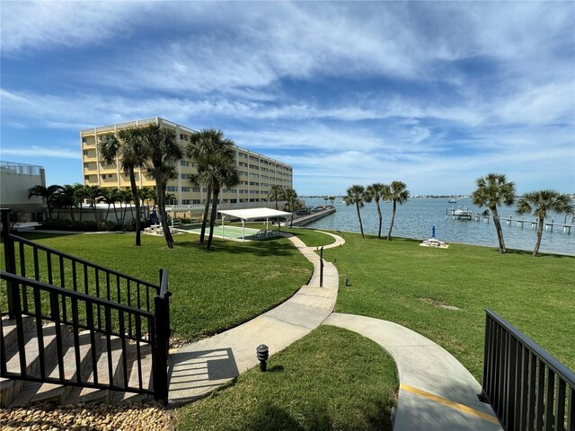 surrounding community featuring a lawn and a water view