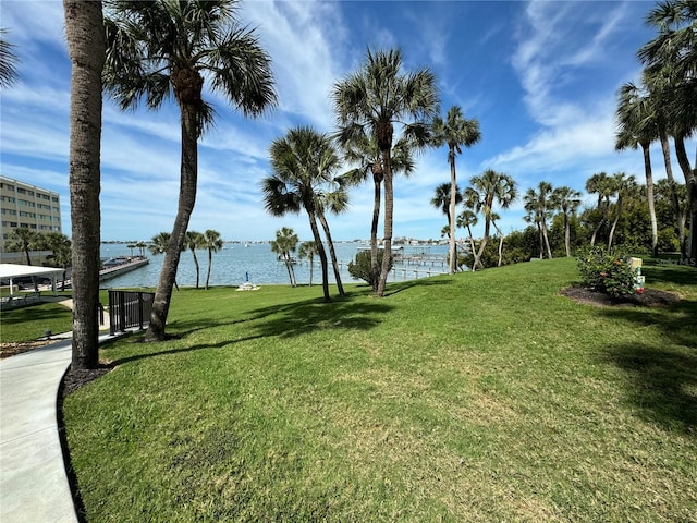 view of home's community with a water view and a yard