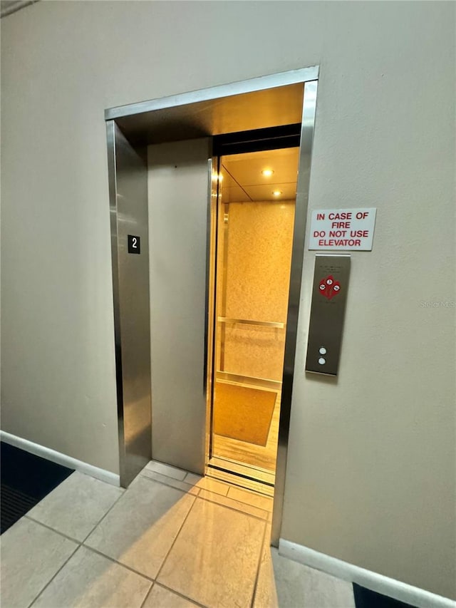 interior details with tile patterned floors and elevator