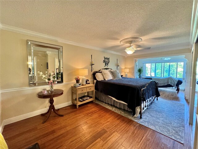 bedroom with a textured ceiling, ceiling fan, ornamental molding, and wood-type flooring