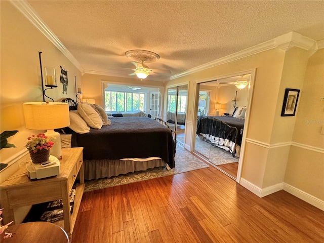 bedroom with a textured ceiling, ceiling fan, crown molding, and hardwood / wood-style flooring