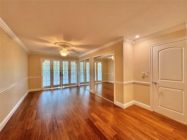 empty room with a textured ceiling, ceiling fan, hardwood / wood-style floors, and ornamental molding