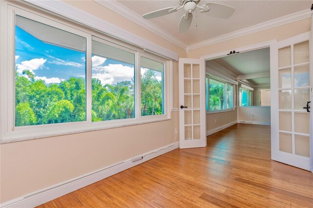 unfurnished room featuring ceiling fan, french doors, light hardwood / wood-style flooring, and ornamental molding