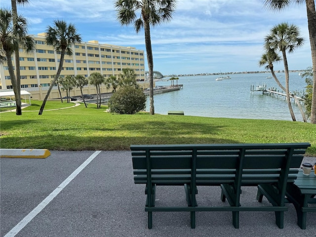 view of property's community featuring a lawn and a water view