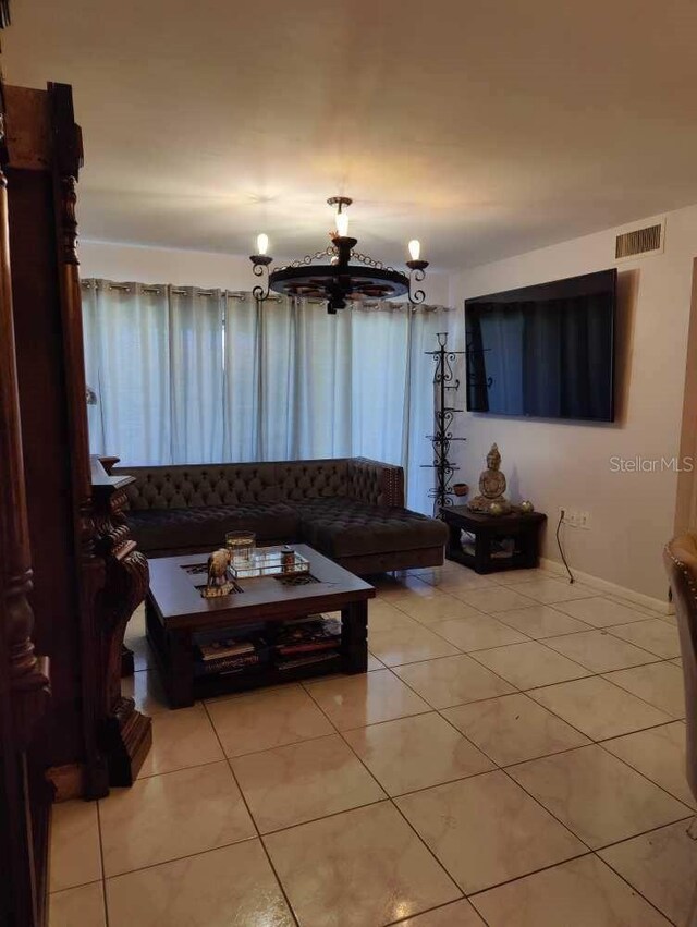 tiled living room with an inviting chandelier