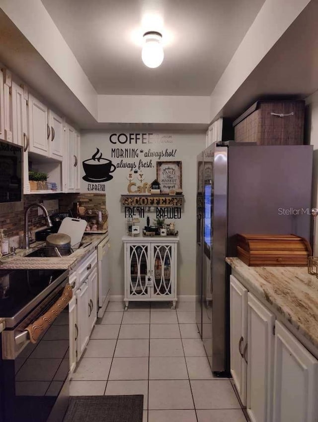 kitchen with light tile patterned flooring, electric stove, white cabinets, white dishwasher, and high end refrigerator