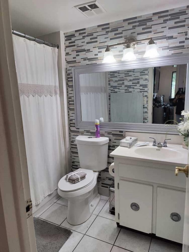 bathroom with tile patterned flooring, tile walls, backsplash, toilet, and vanity