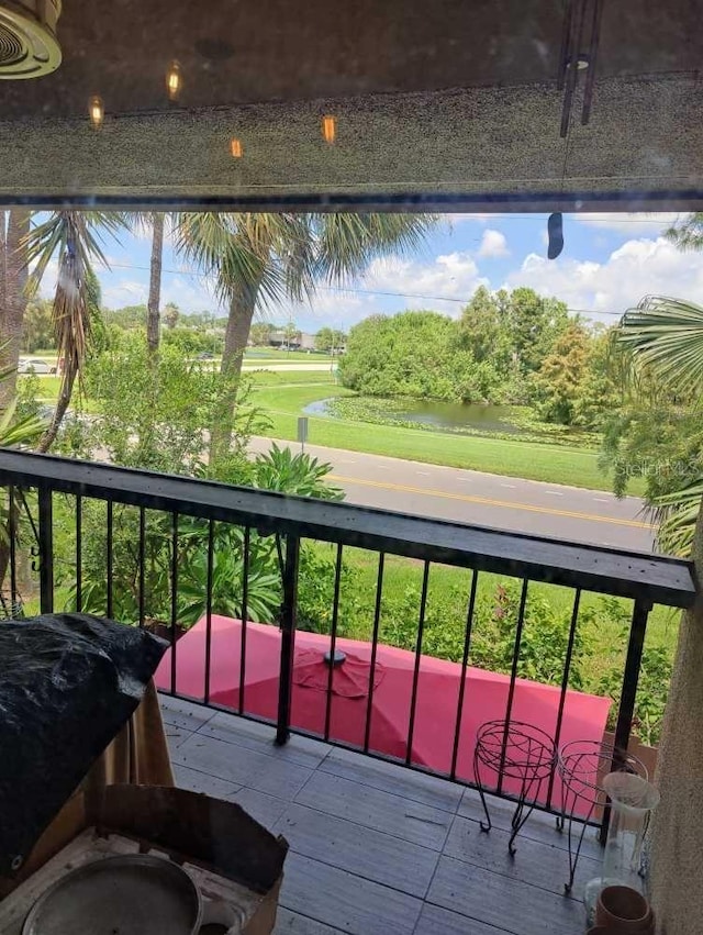 balcony with a water view and area for grilling