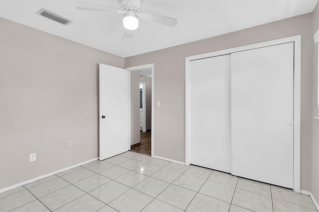 unfurnished bedroom featuring ceiling fan, light tile patterned floors, and a closet