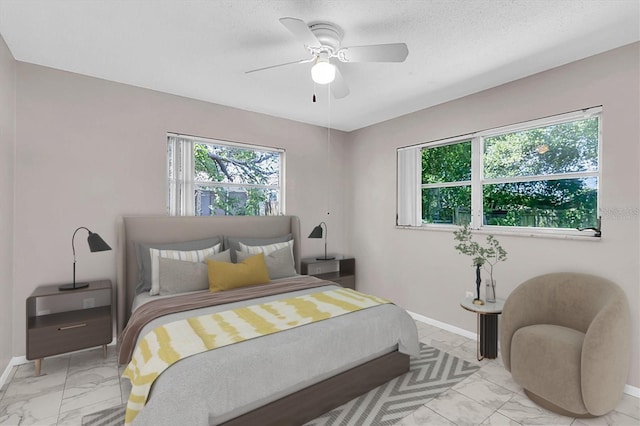 bedroom with ceiling fan and multiple windows