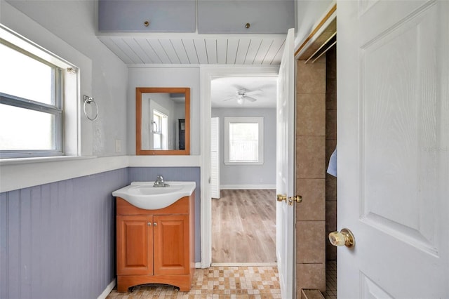 bathroom featuring ceiling fan, a healthy amount of sunlight, and vanity