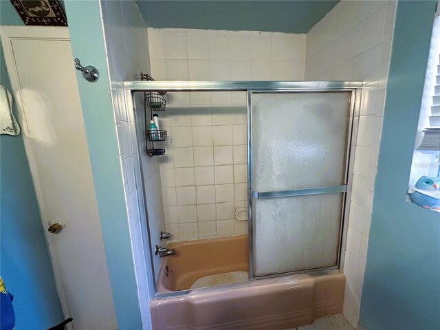 bathroom with bath / shower combo with glass door