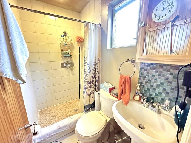 bathroom with tile patterned flooring, tasteful backsplash, sink, a shower with curtain, and toilet