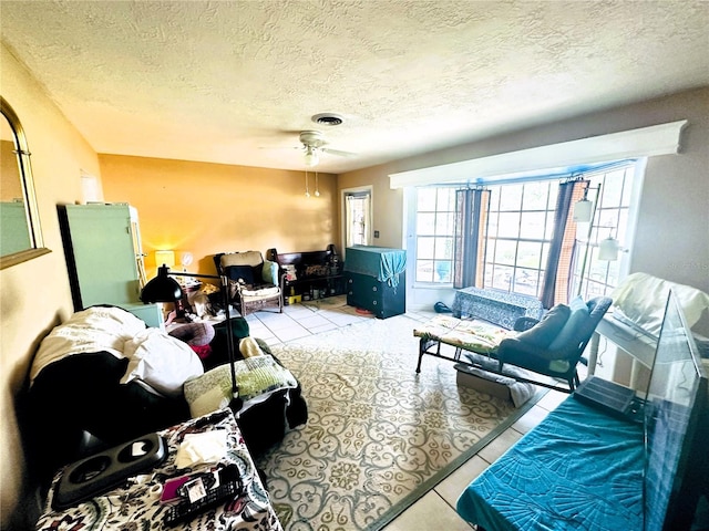 tiled living room featuring ceiling fan and a textured ceiling