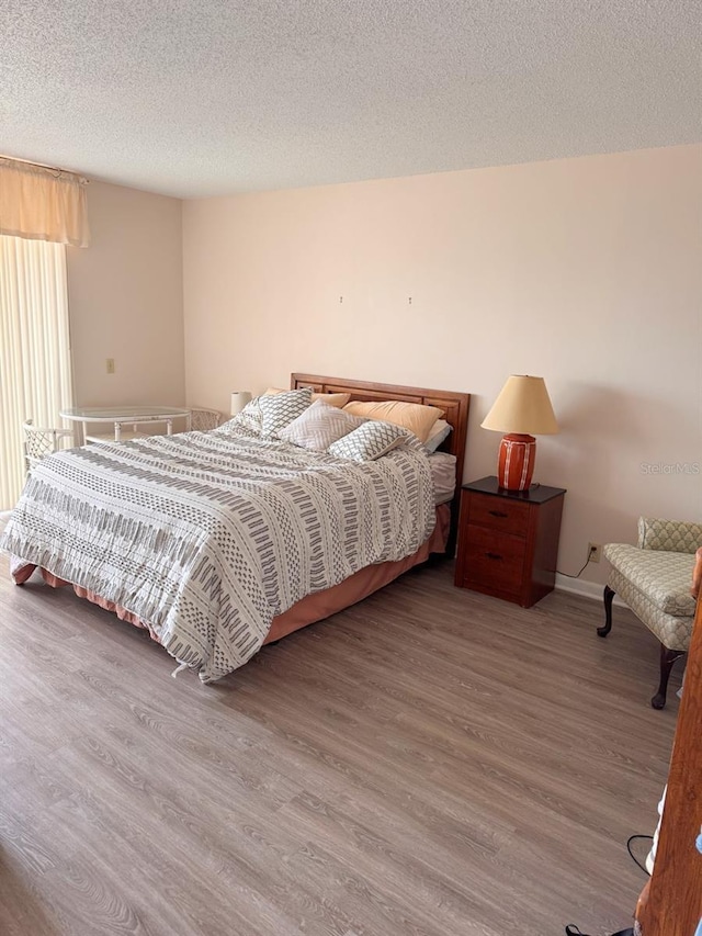 bedroom with wood-type flooring and a textured ceiling