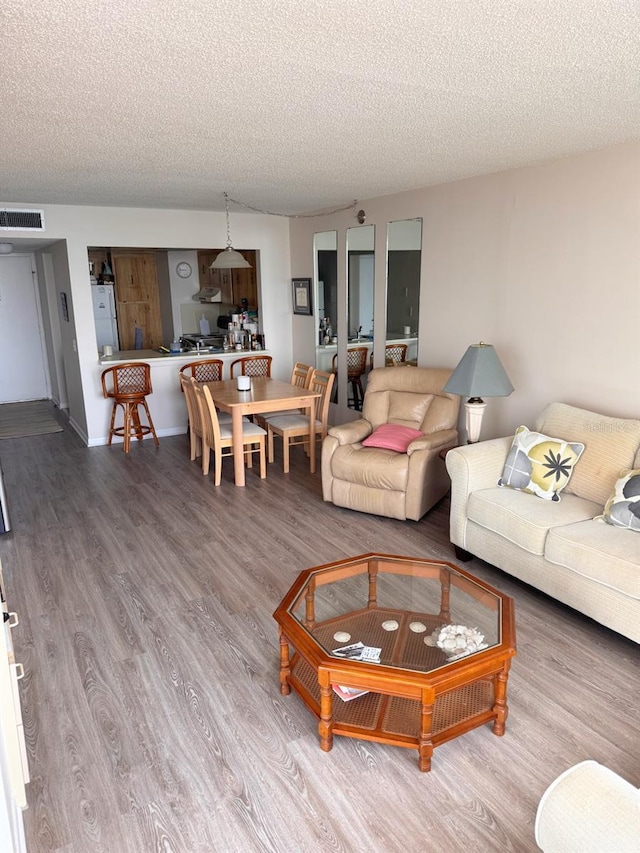 living room with hardwood / wood-style floors and a textured ceiling