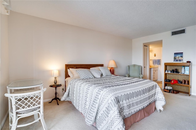 bedroom featuring light colored carpet and a textured ceiling