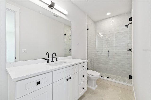 bathroom featuring toilet, vanity, tile patterned flooring, and walk in shower