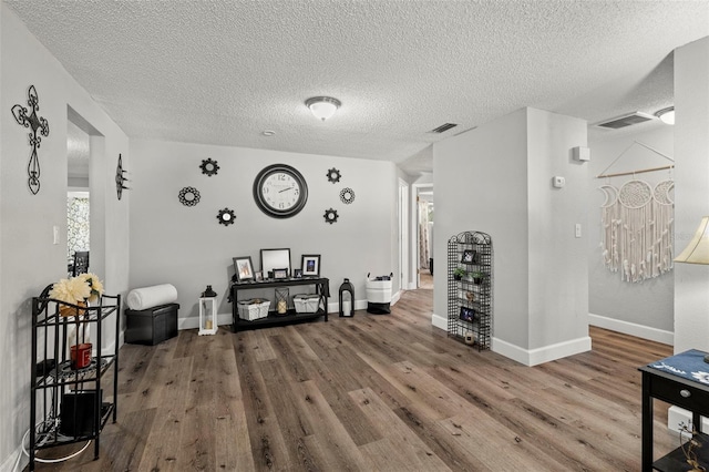 interior space with a textured ceiling and wood-type flooring