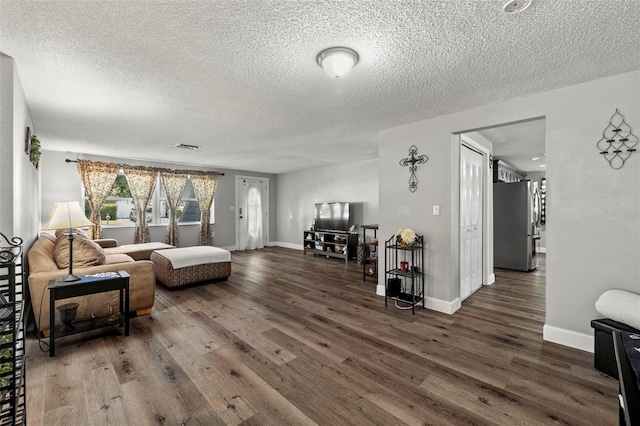 living room featuring wood-type flooring and a textured ceiling