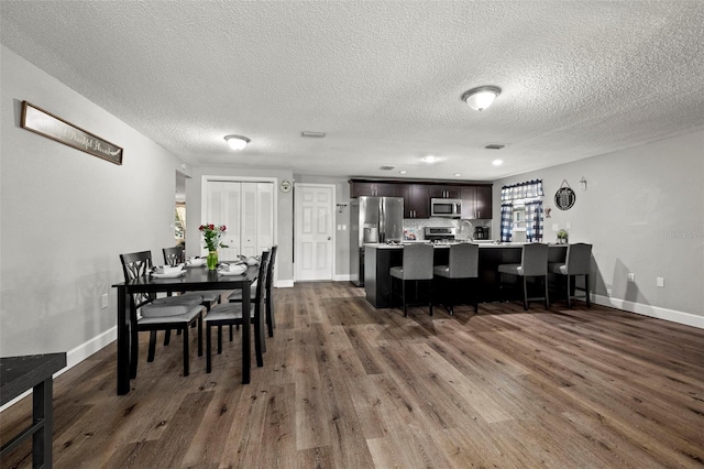 dining space with dark hardwood / wood-style flooring and a textured ceiling