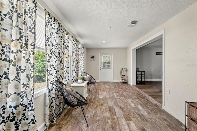 interior space with a textured ceiling and hardwood / wood-style flooring