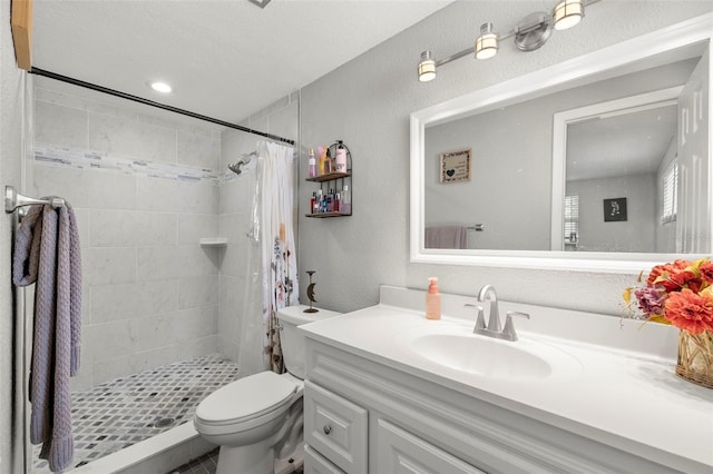 bathroom with toilet, a textured ceiling, vanity, and curtained shower