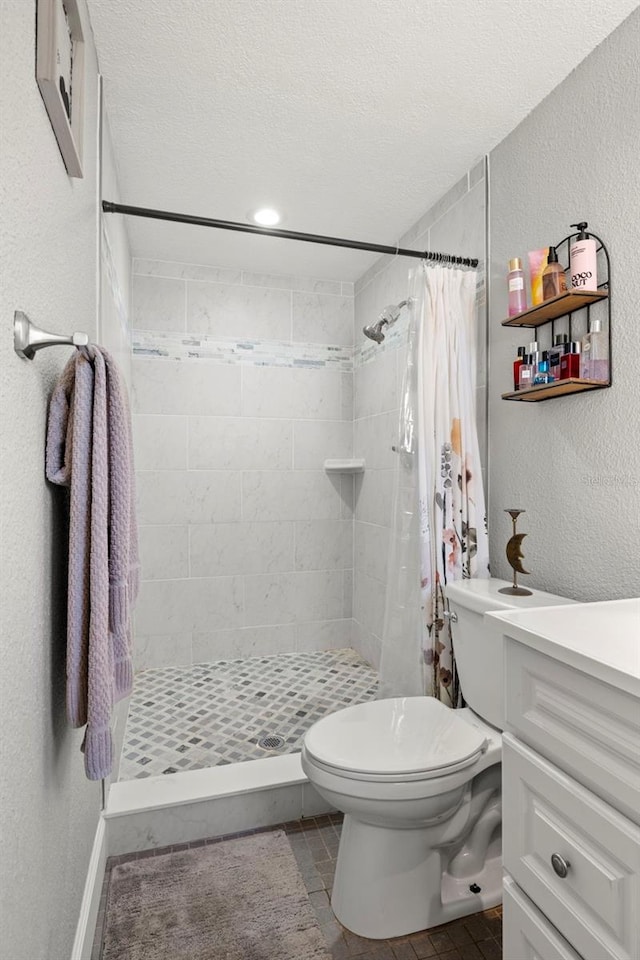 bathroom with vanity, tile patterned floors, a textured ceiling, toilet, and a shower with curtain