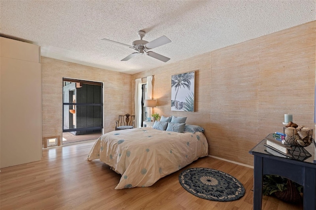 bedroom with a textured ceiling, light wood-type flooring, and ceiling fan