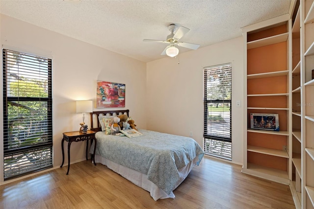 bedroom featuring access to outside, a textured ceiling, light hardwood / wood-style floors, and ceiling fan