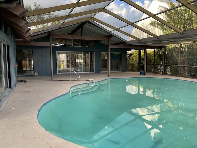 view of pool featuring glass enclosure and a patio