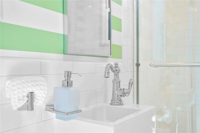 bathroom with decorative backsplash, sink, and tile walls