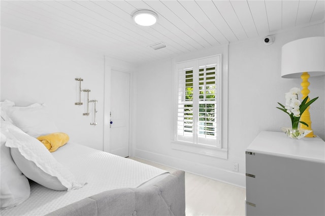 bedroom with fridge and hardwood / wood-style floors