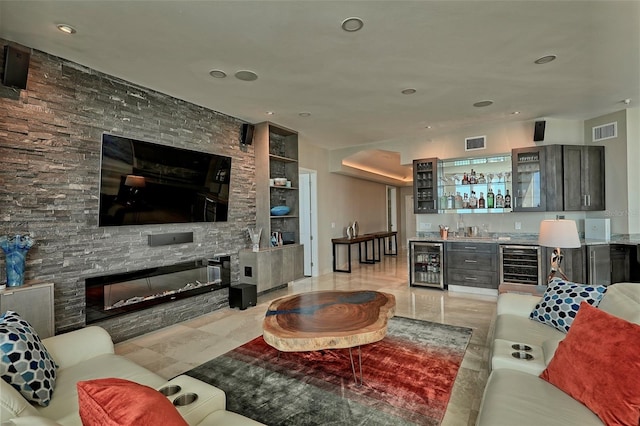 tiled living room featuring beverage cooler, a stone fireplace, and bar