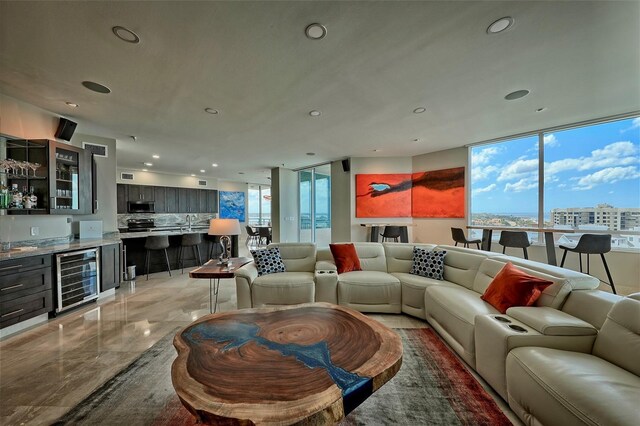 tiled living room featuring sink, floor to ceiling windows, and beverage cooler