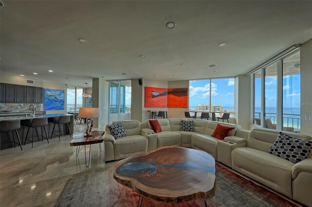 tiled living room featuring sink, a water view, and plenty of natural light