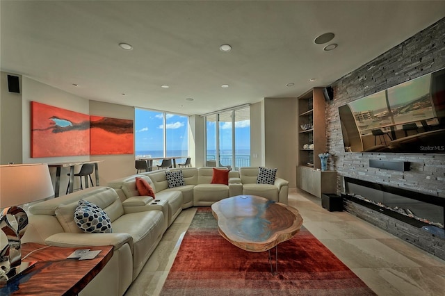 tiled living room featuring built in features, a fireplace, and floor to ceiling windows